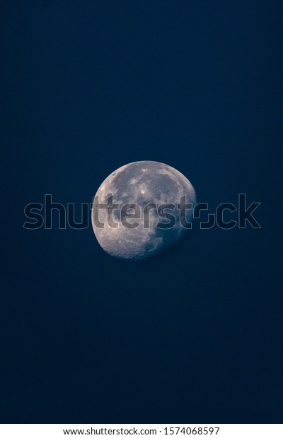 Moon in cloudy dark blue\
sky