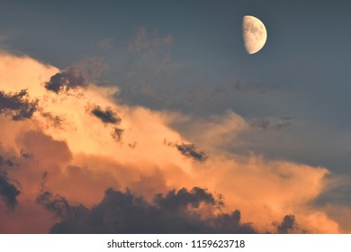 Moon and cloudy sky at sunset