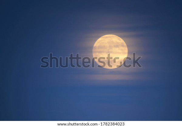 moon covered by a veil of\
clouds