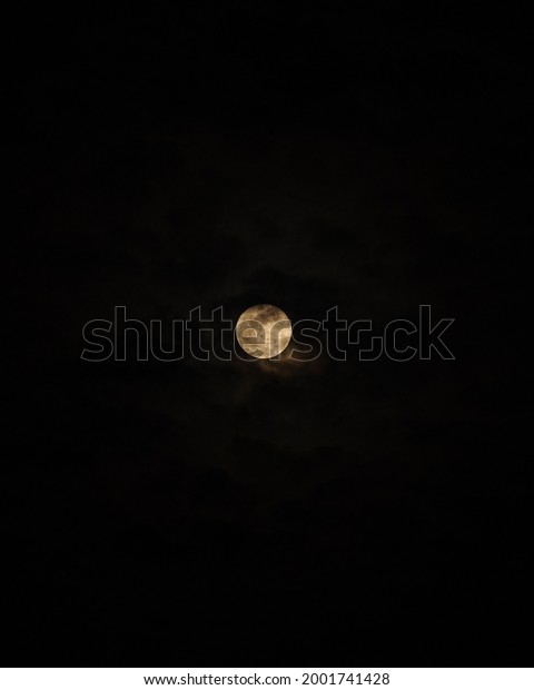 Moon covered in clouds, moon and cloud in the dark\
night sky.