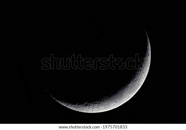 The Moon detailed\
shot taken at 1600mm focal length, blue hour, narrow, thin slice\
visible, waxing crescent