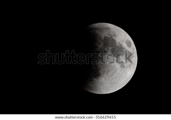 The moon\
during a lunar eclipse. About one third of the moon is in the\
shadow of the earth. There is room for\
text.