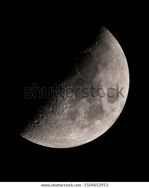 Moon first\
quarter - image with lunar surface details: area, craters, bright\
dust traces from recent\
impacts.