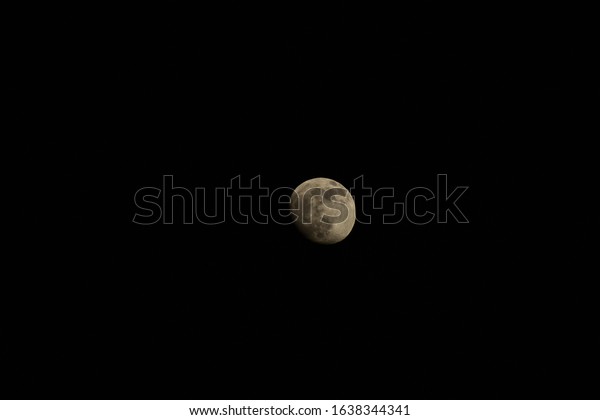 Moon in first\
quarter, isolated in black\
sky.