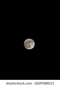 The moon has risen in the sky, shining with a soft, silvery glow that illuminates the entire heavens. Slowly, it emerges through the gaps in the clouds, like a golden, radiant gem. 