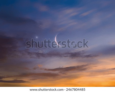 Moon isolated in the sky. A crescent moon in the sky next to a bright star at sunset. Celestial landscape.