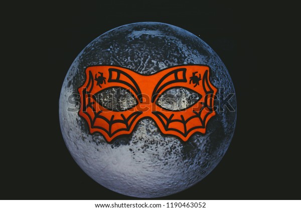 Moon in the mask of a spider. Night of Halloween.\
The moon wore a mask.