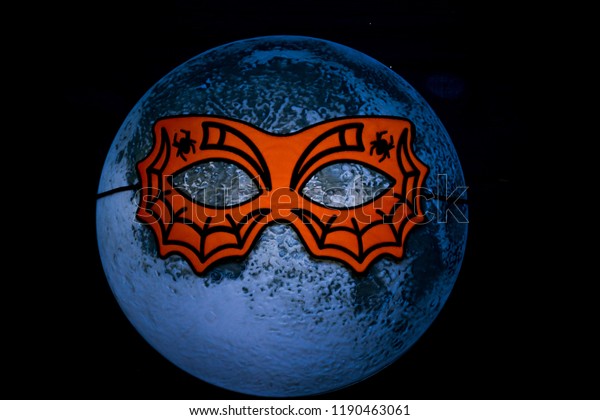 Moon in the mask of a spider. Night of Halloween.\
The moon wore a mask.