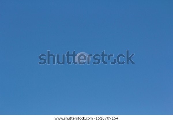 The Moon in The Middle of Frame on The\
Beautiful Blue Sky. Copy Space for\
Text.