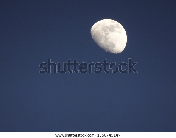 The moon at midnight -\
blue gray sky