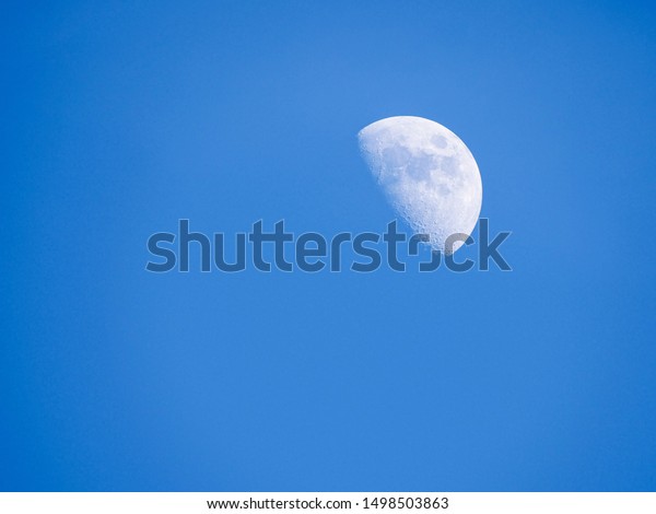 Moon on\
blue sky day time, half moon at sky, The moon in evening\
blue sky\
and half moon on day time sky\
background.
