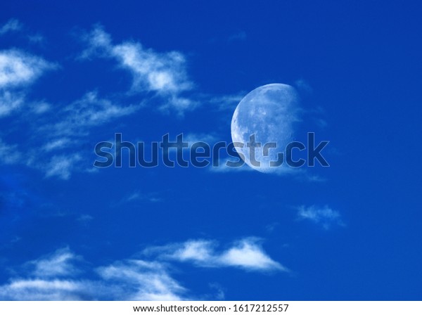 moon on the day with\
clouds in the sky 