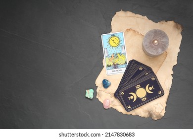 The Moon With Other Tarot Cards, Candle And Gemstones On Black Table, Flat Lay. Space For Text