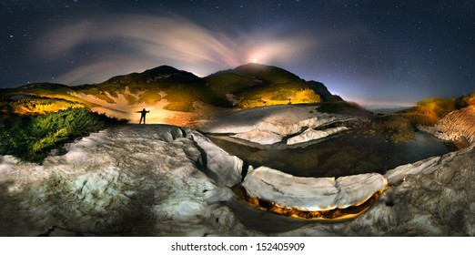 Moon over the top of Pop Ivan Maramorosh and lonely figure, drawing a powerful LED flashlight pictorial compositions of the alpine lake, where icebergs float - Powered by Shutterstock