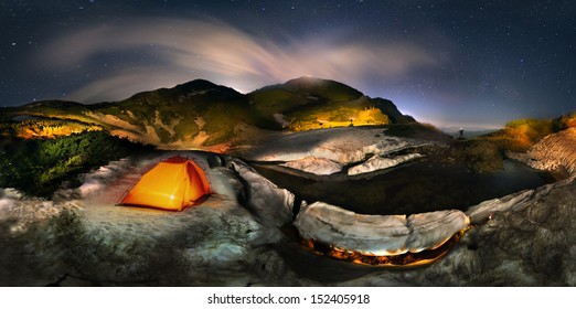 Moon over the top of Pop Ivan Maramorosh and lonely figure, drawing a powerful LED flashlight pictorial compositions of the alpine lake, where icebergs float - Powered by Shutterstock