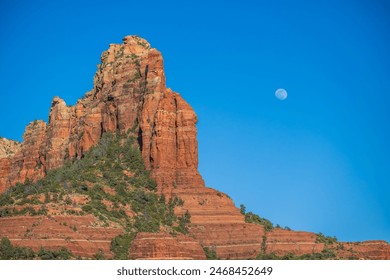 Moon rise over desert cliff monument at sunset with blue sky - Powered by Shutterstock