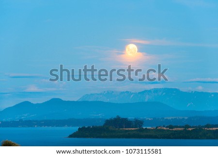 Moon rising between the clouds over Lake Llanquihue, X Region de Los Lagos, Chile