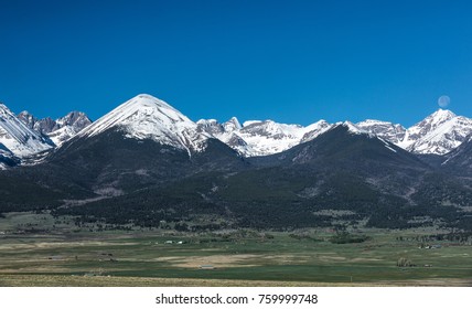 The moon sets over mountain range with The Needle