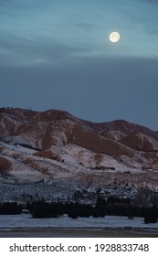 moon setting over a mountain