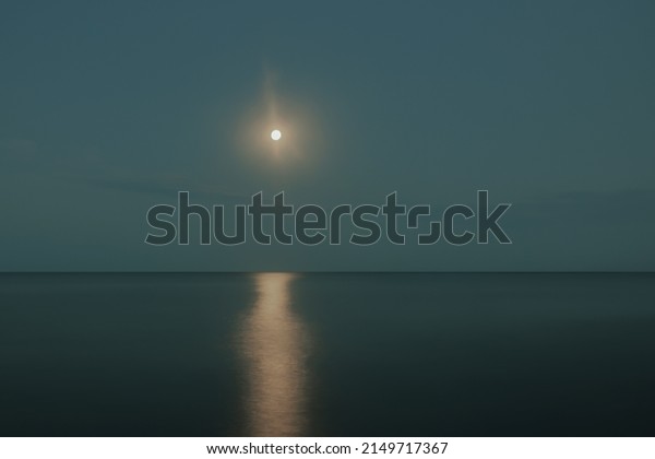 the moon shines over the sea at night\
and is reflected in the water in the form of a\
path