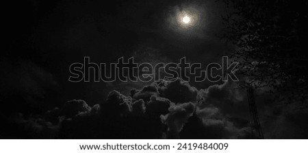 Moon shining during half cloudy night 