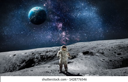 Moon surface with astronaut on it. Planet Earth on the background. Apollo space program. Elements of this image furnished by NASA.