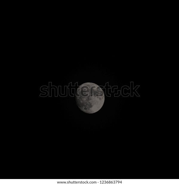 The moon surrounded by\
darkness