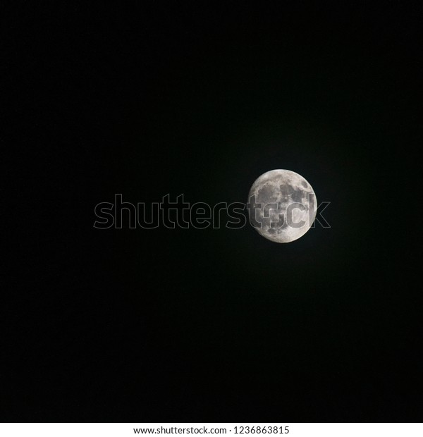 The moon surrounded by\
darkness