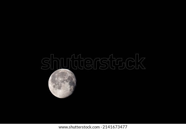 Moon in the waning gibbous phase\
with 94% illumination by the sun with copy space,\
horizontal