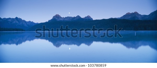Moonset at sunrise over Redfish Lake and Sawtooth\
Mountains, Idaho