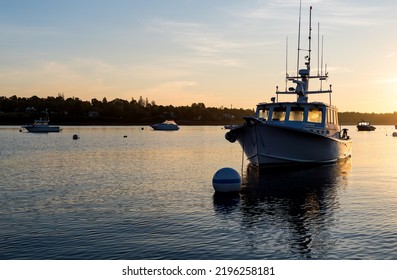 Moored boats in the ocean in the early morning light in Maine.