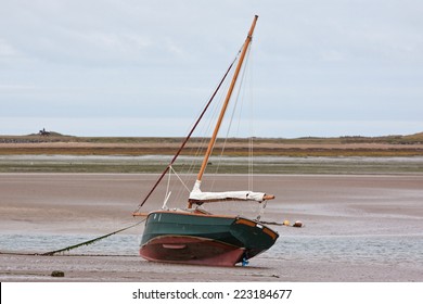 Moored sail boat at low tide sitting serenely on the bed of the Torridge estuary UK