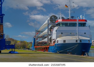 Moored  ship in port loaded with wind turbine blades. Transportation of blades for wind turbines on a cargo ship.