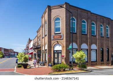 MOORESVILLE, NC, USA-17 APRIL 2022: Street View Showing Corner Of Main Street And Moore Avenue, Focus On 'On Tap Crafty Brews', With People On Sidewalk.  Sunny, Spring, Blue Sky Day.