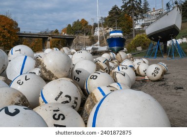 Mooring Buoys:  Floats to mark off-shore anchoring spots lie stacked in a New England boatyard on a cloudy day in October as boating season nears an end.
