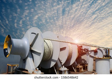 Mooring Winch With Anchor Rope In Line Bundle On Winch Holding Strain The Ship Attract Safety To The Port Wharf Terminal, Safety Equipment Along On Blue Sky Background