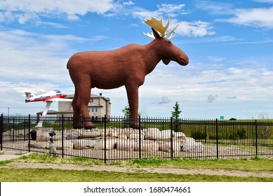 Moose Jaw, Saskatchewan, Canada - 2016: Mac The Moose The World's Largest Moose By Don Foulds Along The Trans Canada Highway. Snowbirds Plane From CFB Moose Jaw, A NATO Flight Training School.