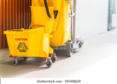 Mop bucket and wringer with caution sign on the floor in office building - Powered by Shutterstock