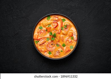 Moqueca With Fish And Shrimps In Black Bowl On Dark Slate Table Top. Brazilian Sea Food Curry Dish With Coconut Milk And Vegetables. Top View