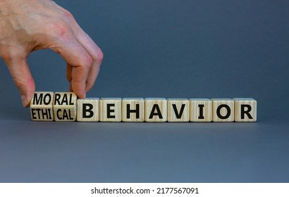 Moral Or Ethical Behavior Symbol. Businessman Turns Cubes, Changes Words Ethical Behavior To Moral Behavior. Beautiful Grey Background, Copy Space. Psychology, Moral Or Ethical Behavior Concept.