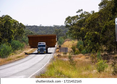 Moranbah, Queensland, Australia - 04/26/2020; Monster coal mining dump truck tray being transported along the Peak Downs highway taking up both sides of the road in Queensland, Australia.