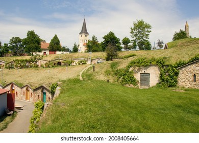 Moravian village Vrbice (south Moravian, Morava) with typical brick wine cellars and old historical church in middle of village during sunny summer day without people, Czech republic, Europe