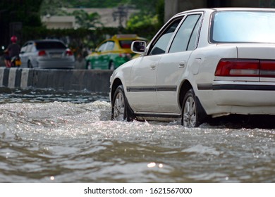 more floods and flooded cars ,car driving flood water on a road - Shutterstock ID 1621567000