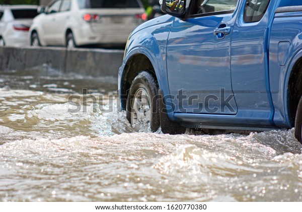 more floods and flooded cars ,car driving flood\
water on a road