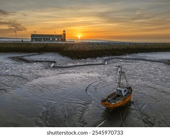 Morecambe Bay, Lancashire, United Kingdom. 12.11.2024 Morecambe Stone Pier Lighthouse built in 1815 pictured at Sunset at low tide. 12th Nov 2024 - Powered by Shutterstock