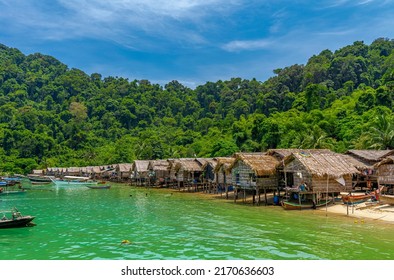 The Morgan Tribe Village On An Island With Motor Boats Floating On The Shore Under Blue Sky