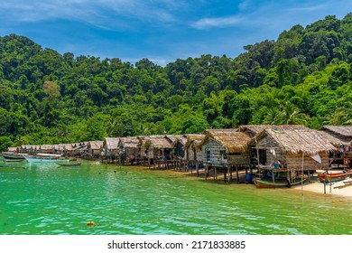 The Morgan Tribe Village On An Island With Motor Boats Floating On The Shore Under Blue Sky