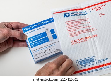 Morgantown, WV - 2 February 2022: Senior Man Opening The Federally Supplied At-home Test For Covid-19 With US Postal Service Envelope