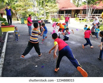 Morib, Malaysia -  5th May 2018: Children Throwing Water Balloons To Another Person For Him/her To Get Wet In A Water Balloon Fight Game.