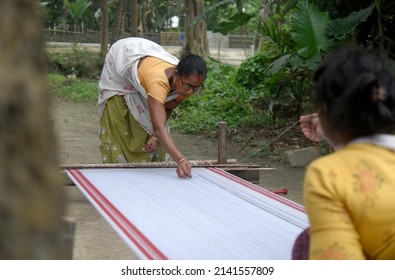 Morigaon, India. 31 March 2022. Assamese woman weaves Assamese Traditional Gamosa in handloom, ahead of Rongali Bihu festival on March 31, 2022 in Mayong, Morigaon,  India.